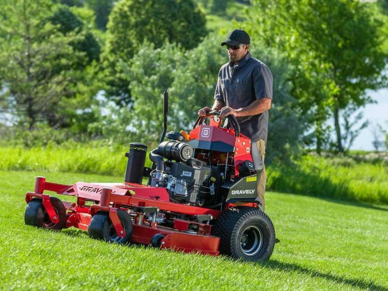 Man skillfully operating a riding lawn mower across a spacious yard.